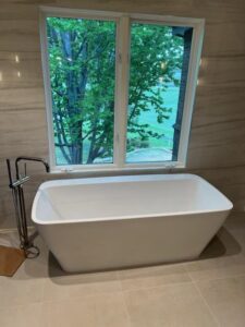 a white bathtub sitting in front of a window
